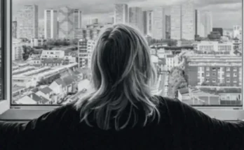 une habitante d'un logement populaire regardant par sa fenetre